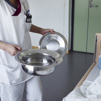 Bildet viser en uidentifiserbar helsefagarbeider som holder et bekken