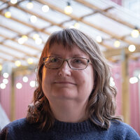 Anne Cathrine Hovind ser litt opp fra kamerat på et kafe i Trondheim