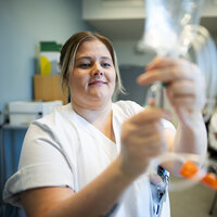 Bilde viser spesialsykepleier Lena Trogstad Risvik som åpner en intravenøspose.