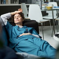 Bildet viser en sykepleier som er utslitt og trøtt