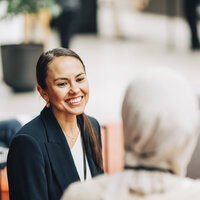 Bildet viser to kvinner som snakker sammen