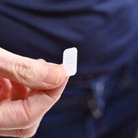 Bildet viser en hånd som holder et lite plaster.