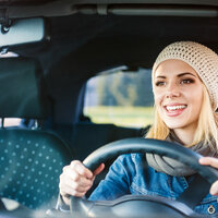 Bildet viser ung kvinne som kjører bil