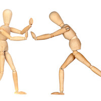 Bilder viser to trefigurer som dytter til hverandre.